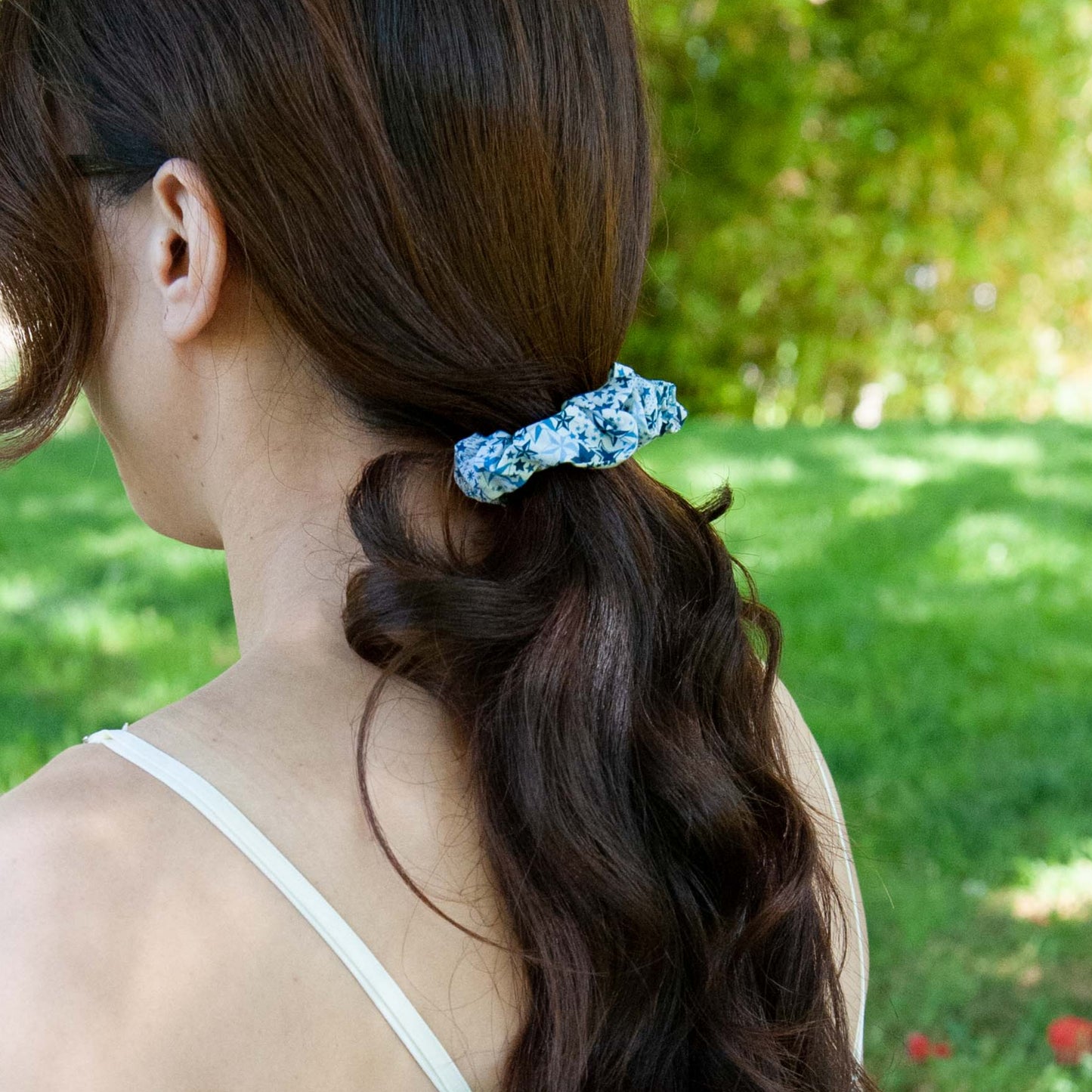 a woman wearing a blue liberty fabric scrunchie for a ponytail