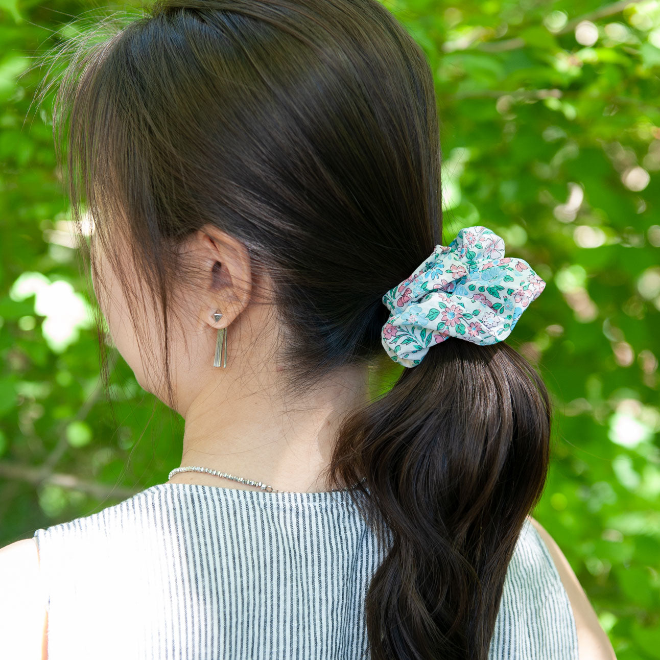 a woman wearing a large liberty fabric scrunchie for ponytail