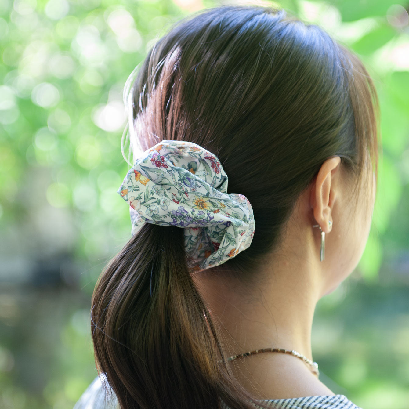 a woman wearing a floral liberty fabric scrunchie