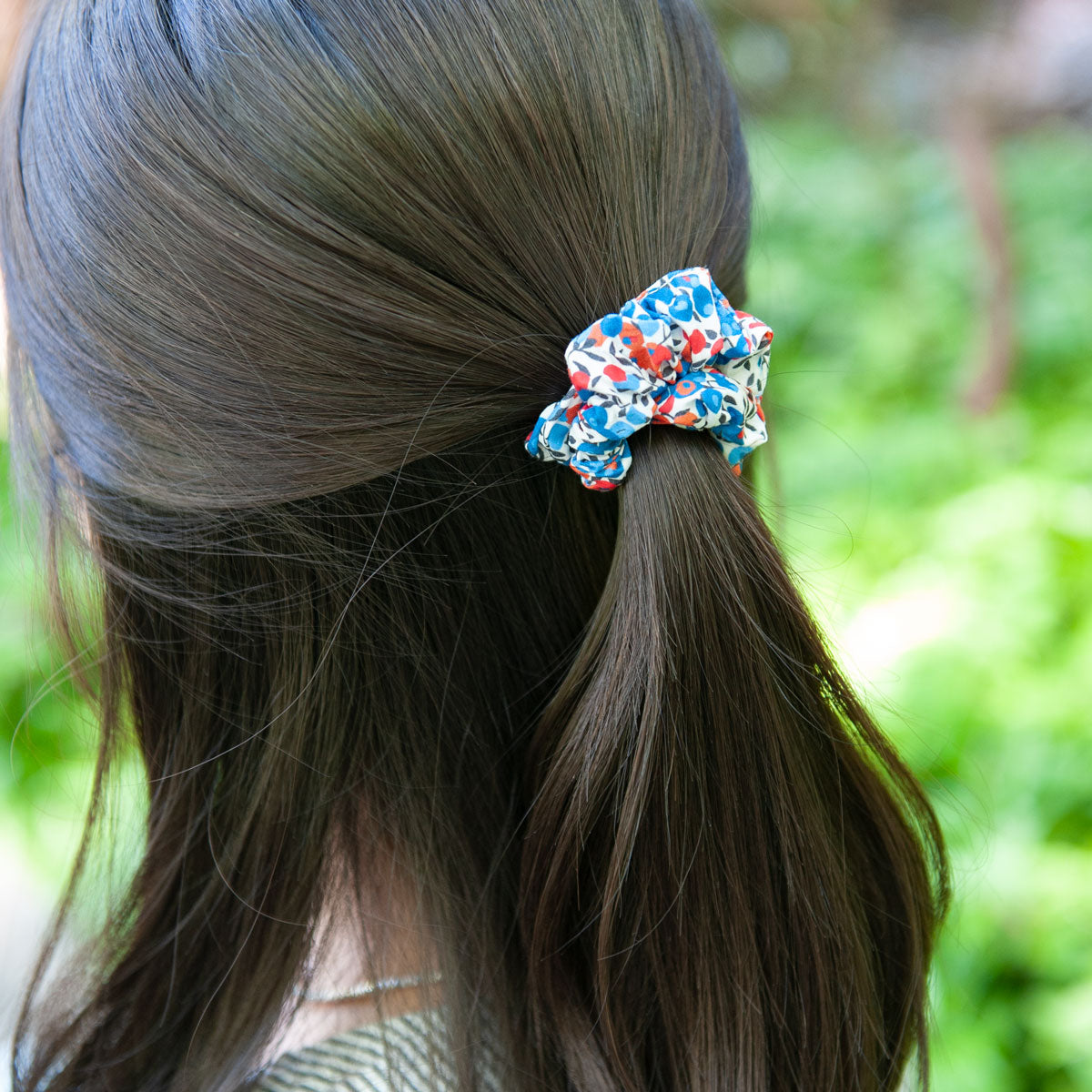 a woman wearing a skinny liberty fabric scrunchie for half up hairstyle