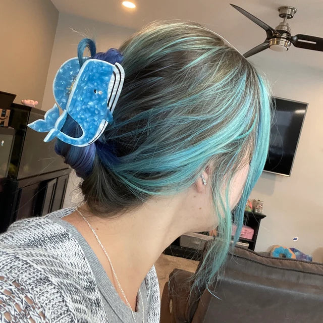 a woman wearing a blue whale hair clip
