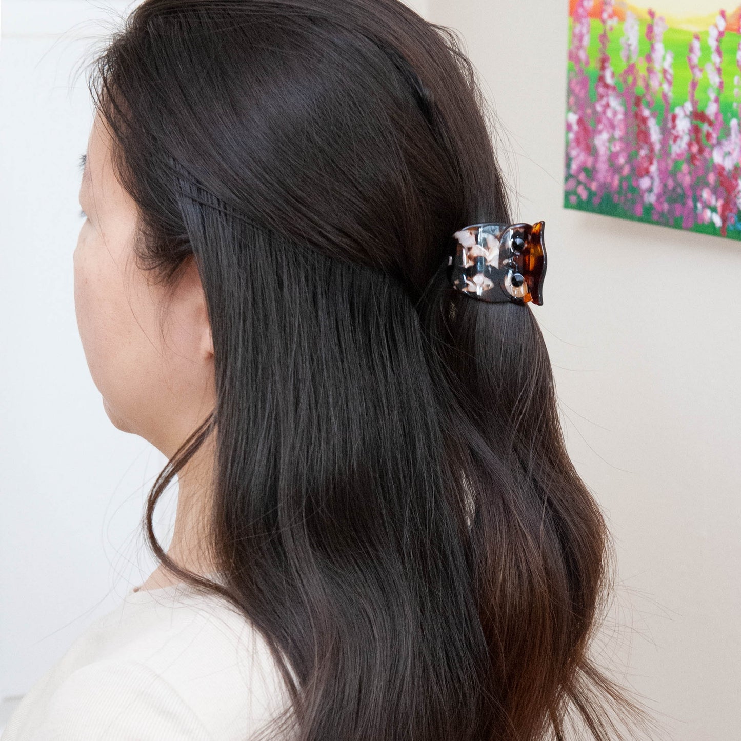 a woman wearing an owl hair claw clip for half up half down hairstyle