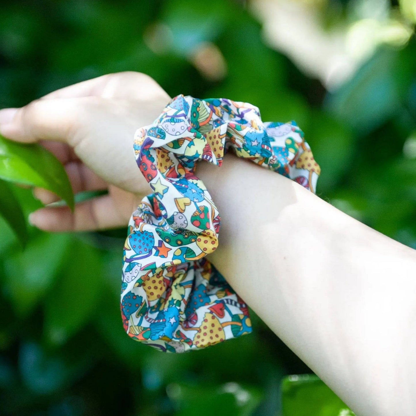 Image of a cotton hair scrunchie featuring a charming mushroom print design. The scrunchie is handmade from soft cotton fabric and adds a playful touch to any hairstyle.