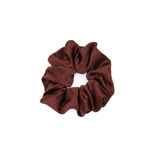 A collection of vibrant satin scrunchies in various colors, displayed neatly on a white surface. The scrunchies are soft and glossy, showcasing their luxurious texture and elegant appeal.