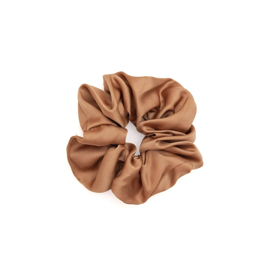 A collection of vibrant satin scrunchies in various colors, displayed neatly on a white surface. The scrunchies are soft and glossy, showcasing their luxurious texture and elegant appeal.