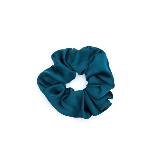 A collection of vibrant satin scrunchies in various colors, displayed neatly on a white surface. The scrunchies are soft and glossy, showcasing their luxurious texture and elegant appeal.