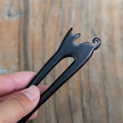 Ebony wooden cat hair pin with a small cat design and curled tail detail