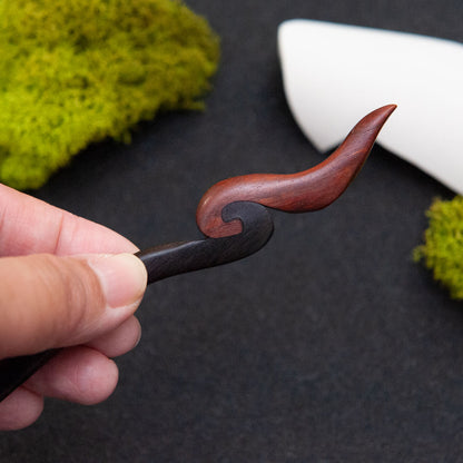 Ebony hair stick with a smooth black body and a small red fire-inspired tip at the end.