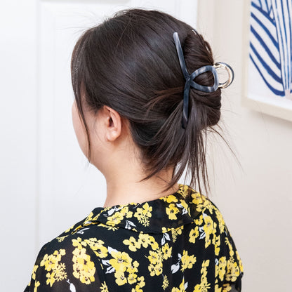 a woman wearing an extra large claw clip in gray