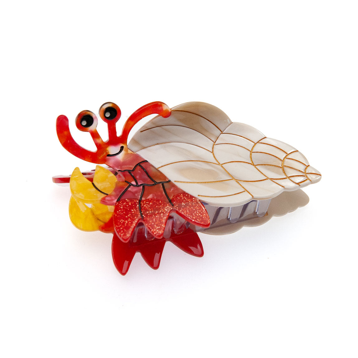 A whimsical, handcrafted hermit crab hair claw clip, featuring a red body, yellow accents, and a cream-colored shell with gold lines, photographed on a clean white background.