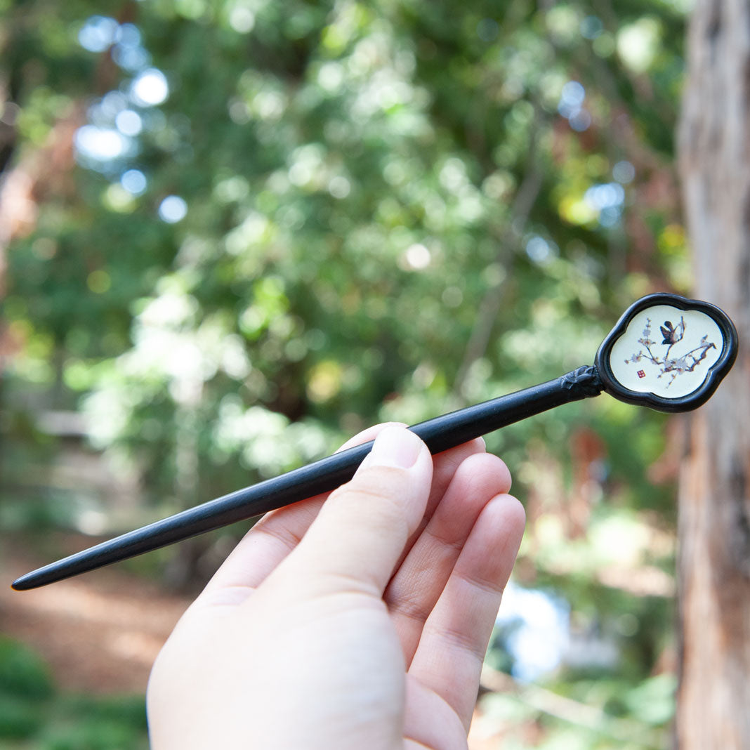 Handmade wooden hair stick with a Chinese painting of a bird on plum blossoms, symbolizing good luck and happiness.