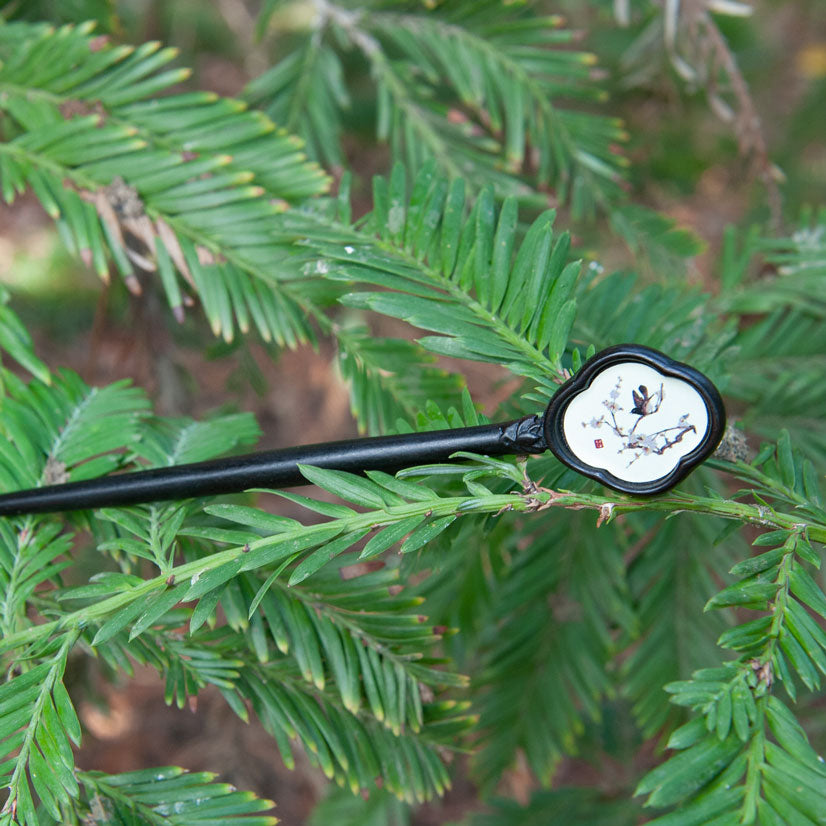 Handmade wooden hair stick with a Chinese painting of a bird on plum blossoms, symbolizing good luck and happiness.