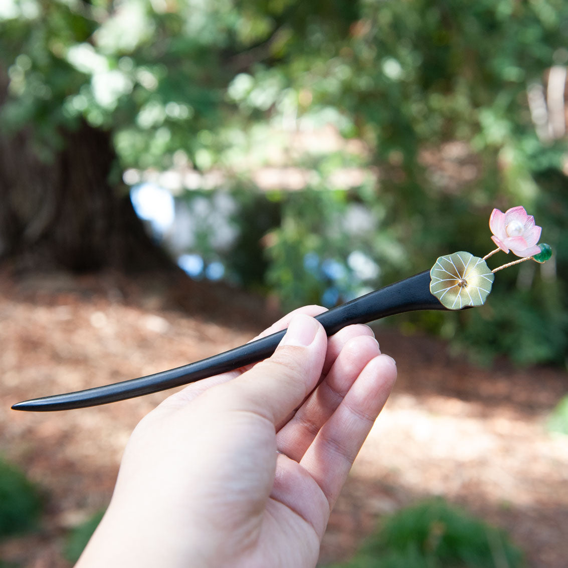 Handmade wooden hair stick with green lotus leaves and a pink lotus flower, symbolizing summer and purity.